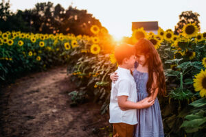 boy and girl hugging at sunset in a sunflower field