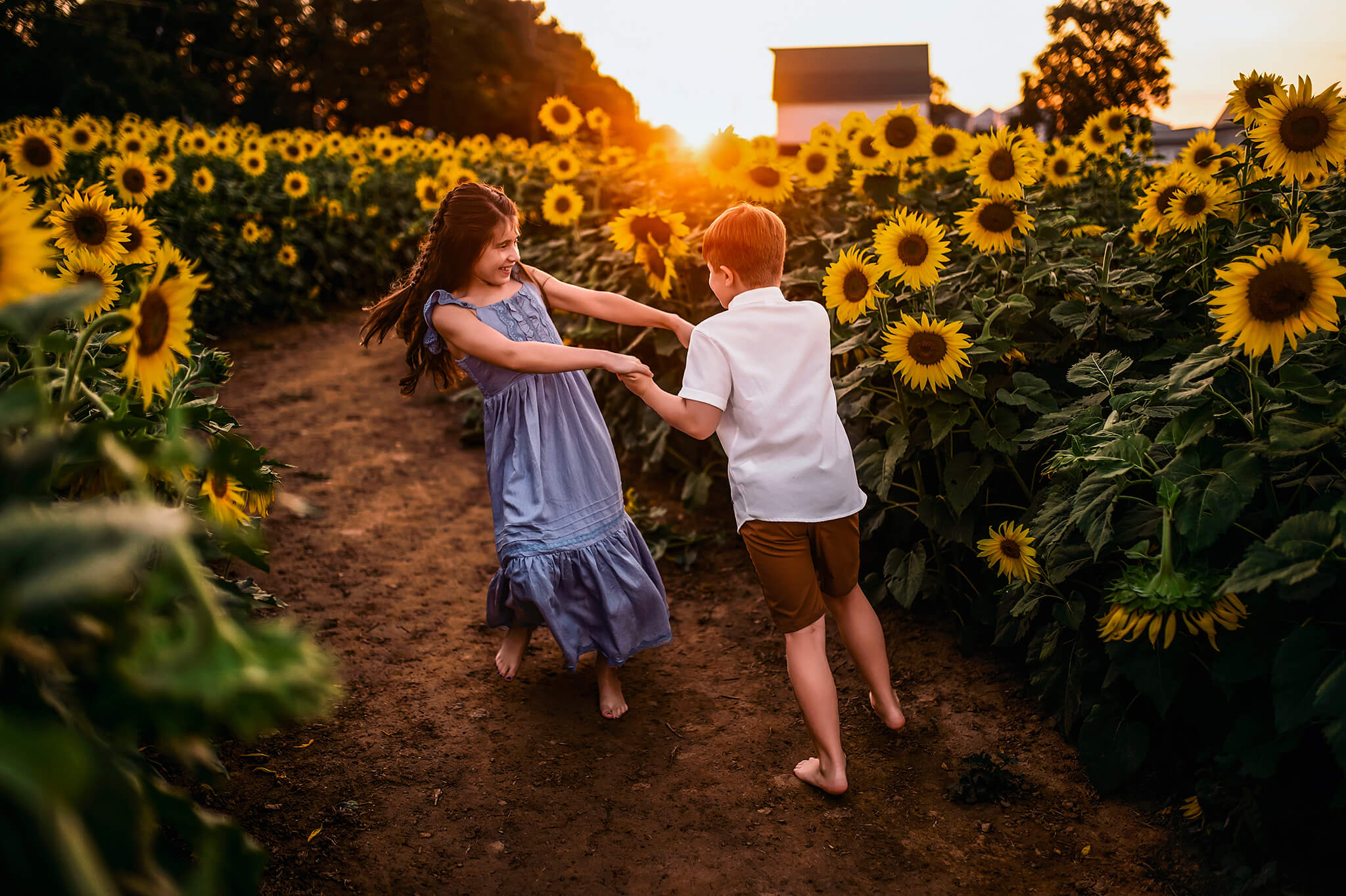 boy and girl twirling having fun in a sunflower field