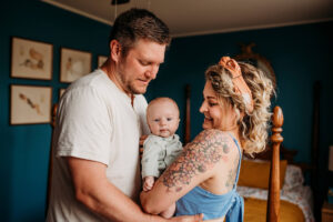 mother and father holding baby